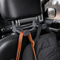 Car headrest hook holding a bag inside a vehicle