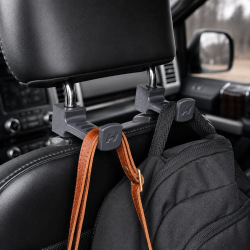 Car headrest hook holding a bag inside a vehicle