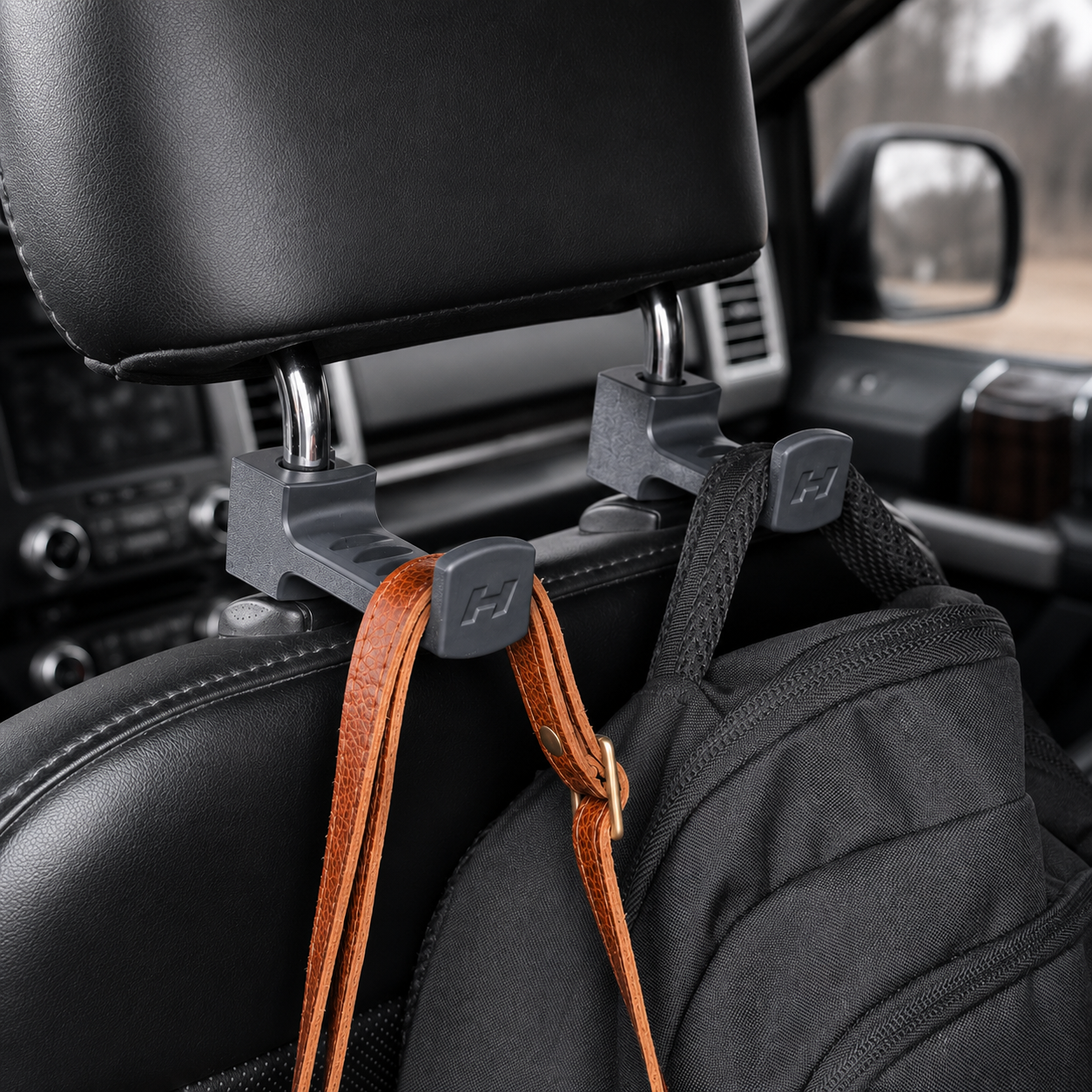 Car headrest hook holding a bag inside a vehicle