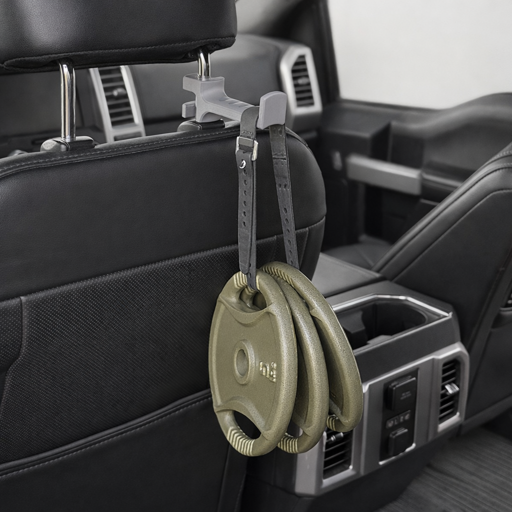 Weight plates hanging from a headrest hook in a vehicle.