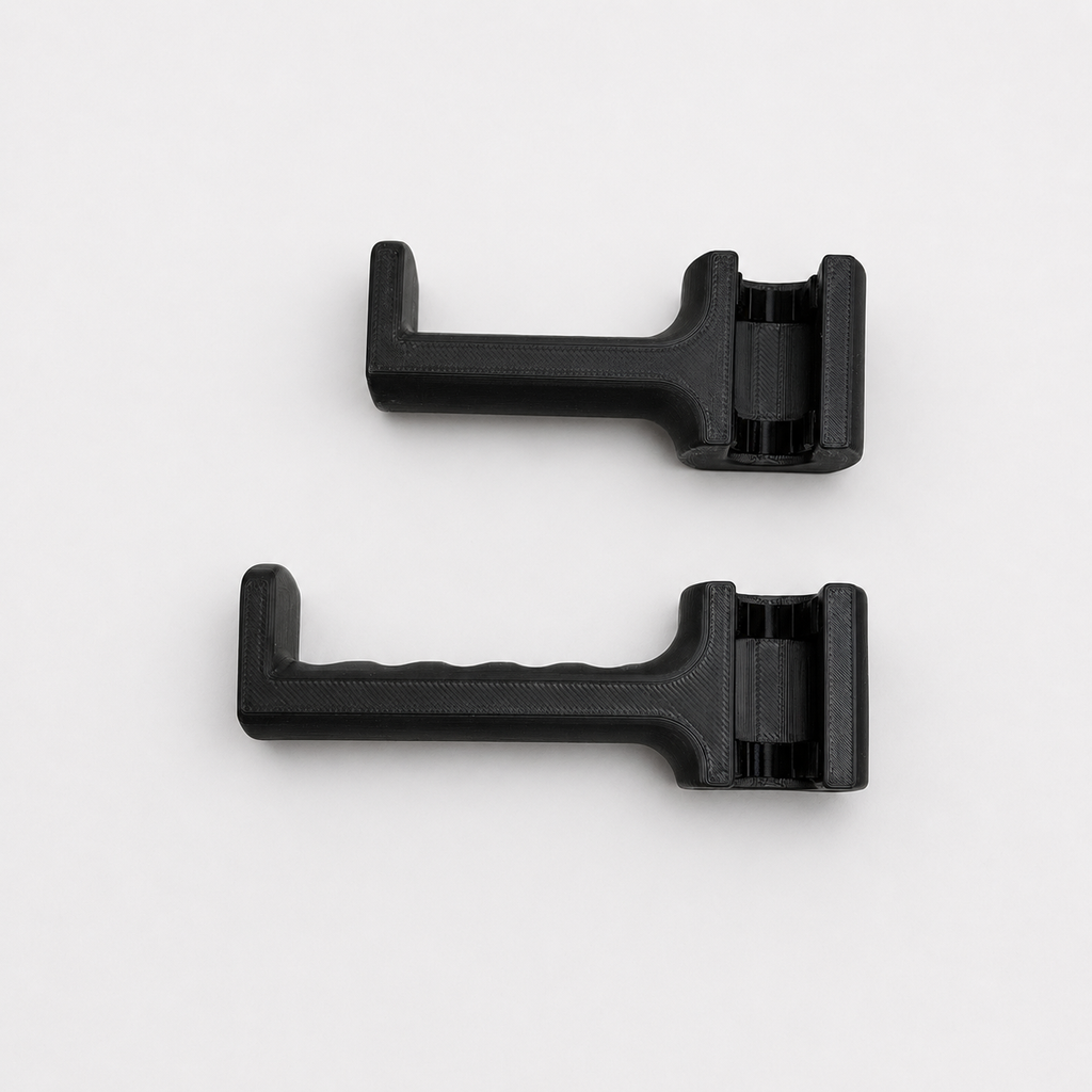 Two black plastic components on a white background
