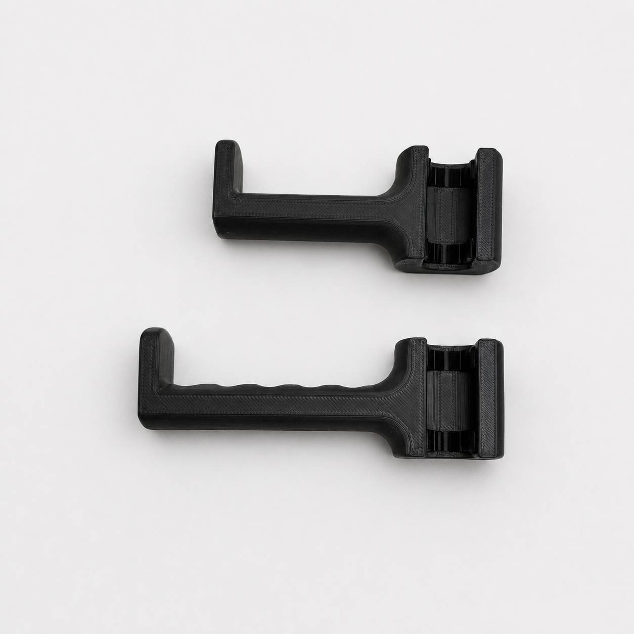 Two black plastic components on a white background